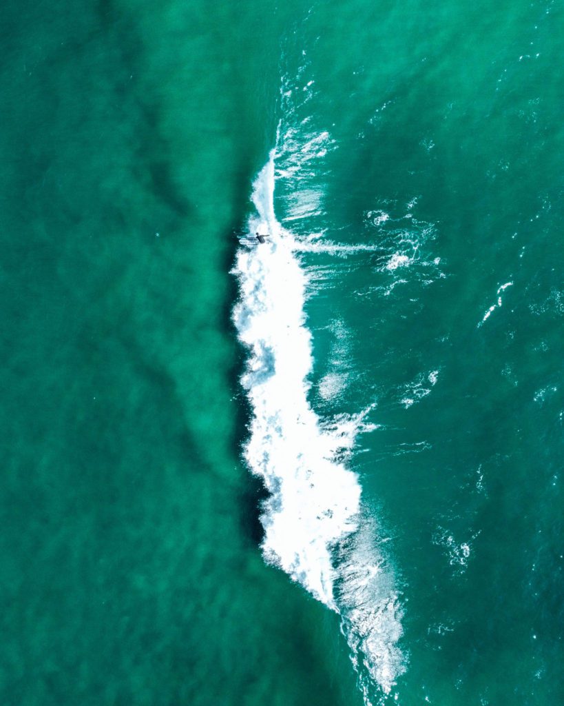 Drone photo of surfer in the waves in California